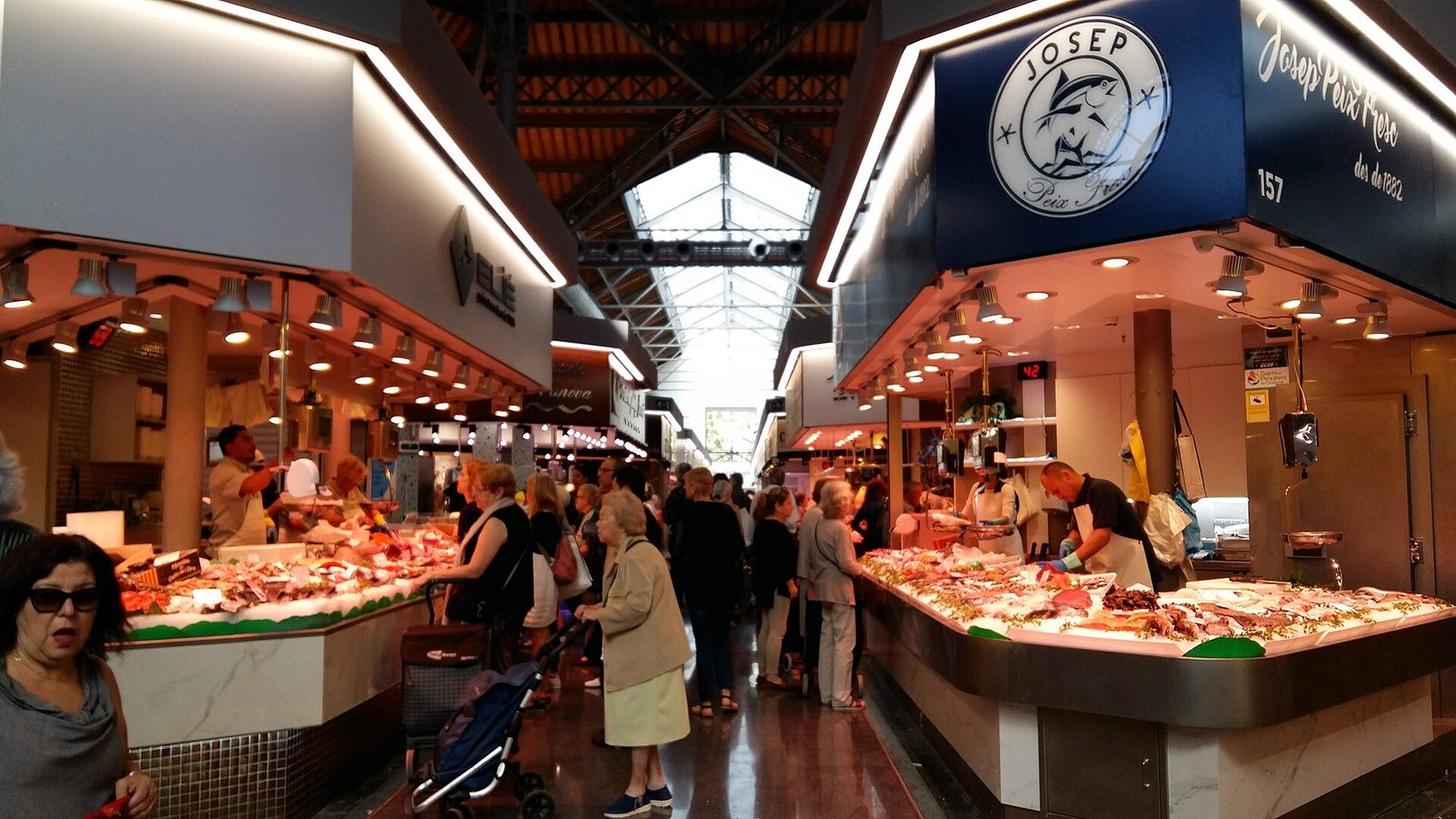 Allée du marché de Sant Antoni rénové, clients devant les étals de poisson