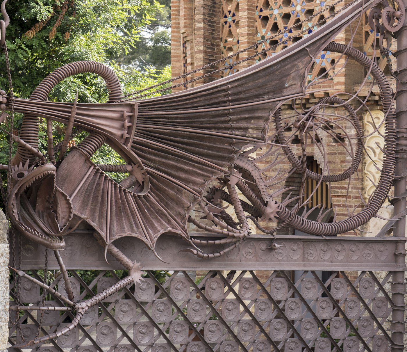 La grille en fer forgé figurant un dragon à l'entrée des Pavellons Güell de Gaudí