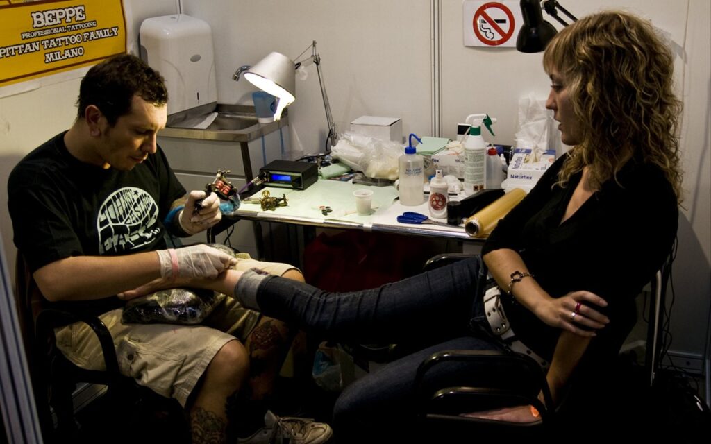 Un tatoueur au travail pendant la convention internationale du tatouage de Barcelone