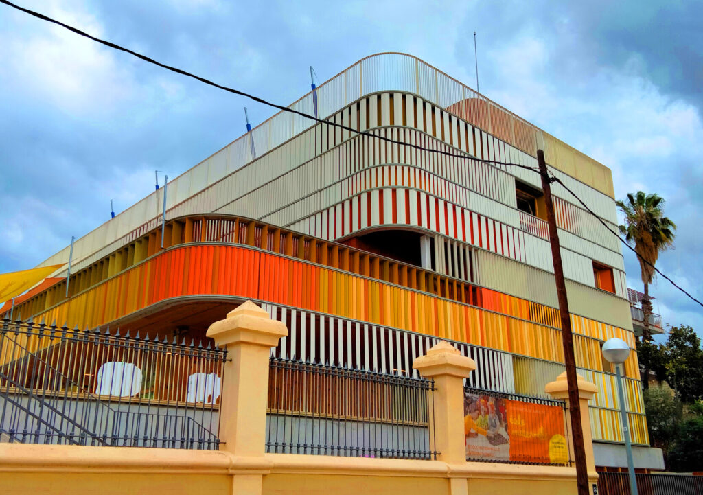 Façade colorée à lames verticales jaunes et orange de la maternelle du Lycée Français de Barcelone, carrer de Munner