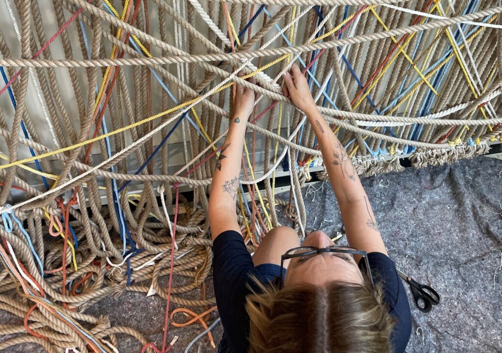 Cathy Dupré, de Macramé Barcelona, noue à la main une grande pièce de cordes colorées